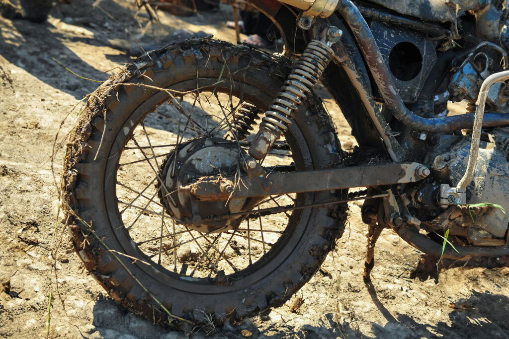 the rear wheel of a motorbike is dirty with mud