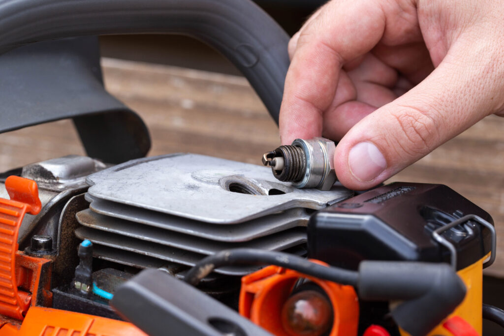 Wet spark plug in a chainsaw. Rich fuel mixture. Malfunction in the ignition system. industry