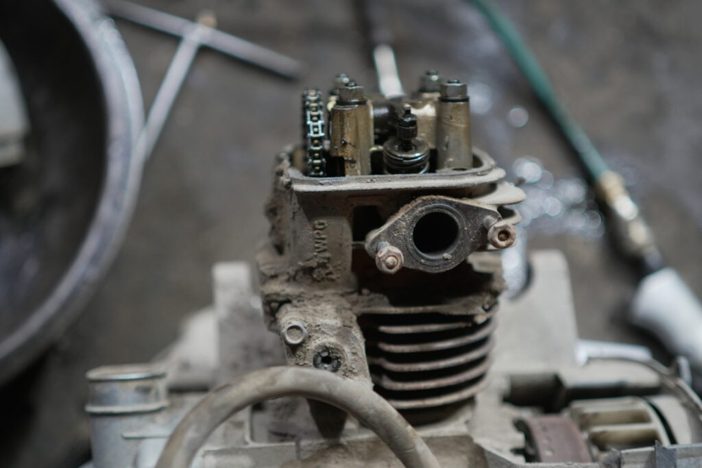 Engine parts and components in focus, showcasing a disassembled motorcycle engine, highlighting the intricacies and machinery details in a repair or mechanical environment